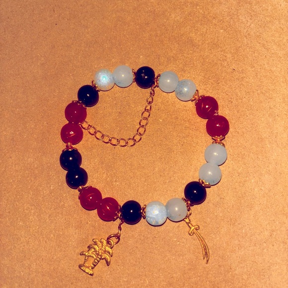 Beaded Bracelet with 1 palm tree charm, 1 sword charms, and 1 chain charm. - Picture 1 of 1